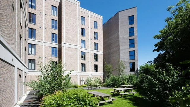 Brick buildings with picnic tables outdoor seating area at Straits Meadow in Edinburgh Student Accommodation