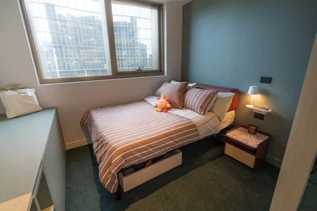 Bed with striped bedding and toy bedroom at The Switch Berkeley in Melbourne Student Accommodation
