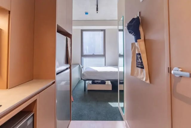 Bed wardrobe and bag in compact studio bedroom at The Switch Berkeley in Melbourne Student Accommodation