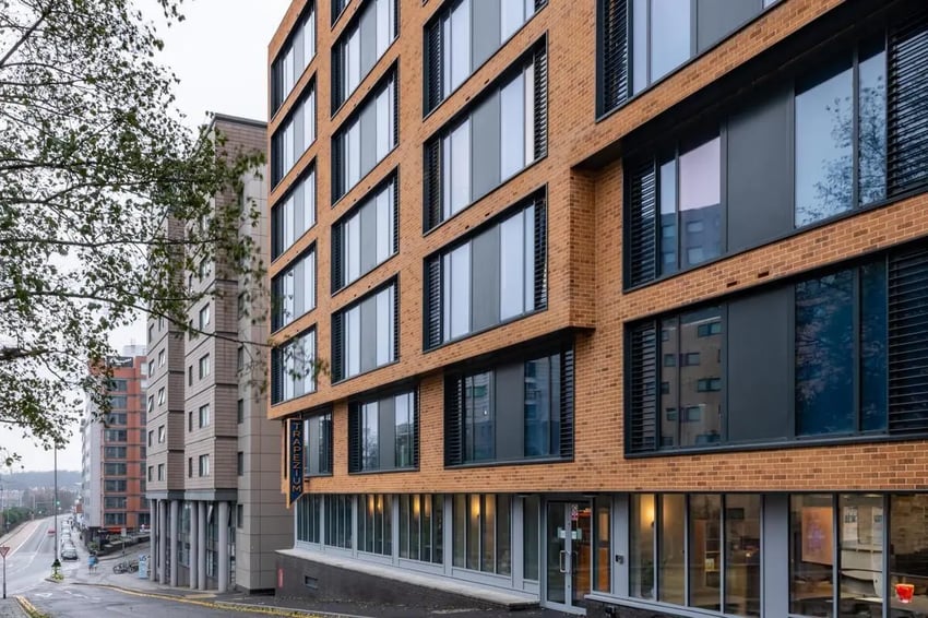 Modern brick building with many windows exterior at Trapezium in Leeds Student Accommodation