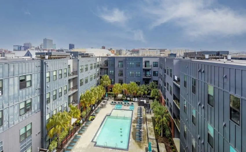 Apartment complex courtyard with swimming pool and palm trees exterior at Greene Crossing Apartments in Columbia Student Accommodation