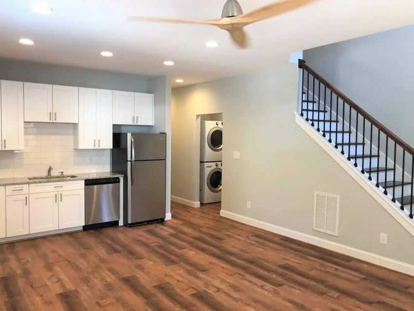 Kitchen with white cabinets and appliances, laundry area living room. at The Lookout in Chapel Hill Student Accommodation