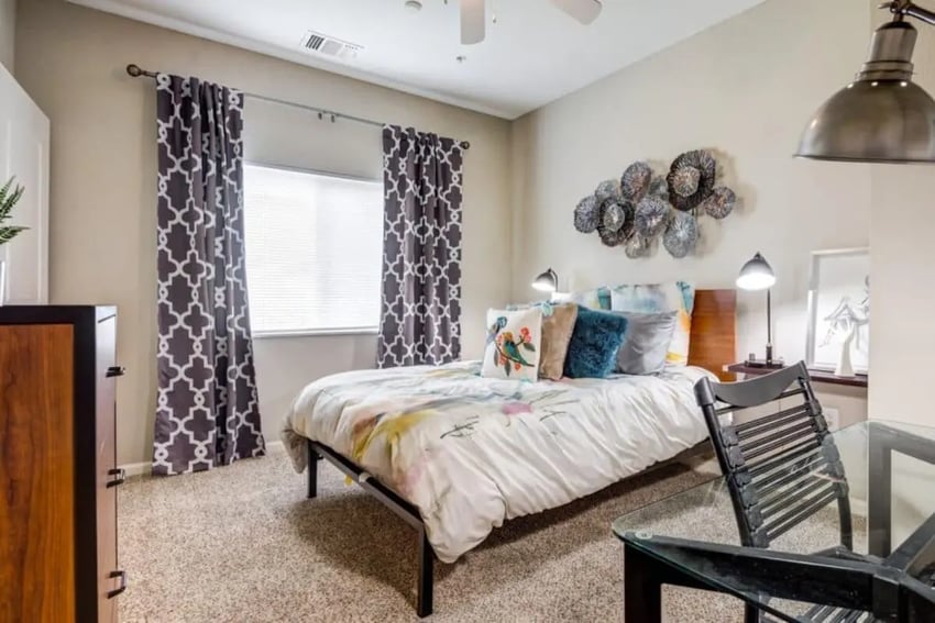 Bed with patterned curtains and desk bedroom at Madera in San Antonio Student Accommodation