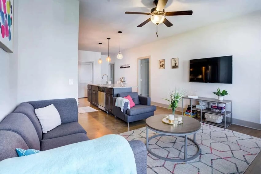 Gray sectional couch round table tv living room at 1820 at Centennial in Raleigh Student Accommodation
