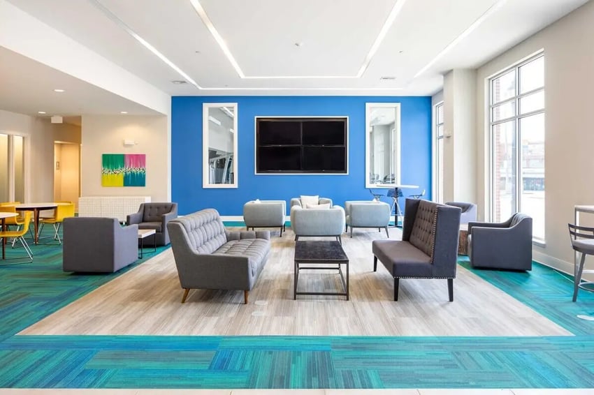 Modern lounge with couches televisions and colorful carpet living room at 200 Edgewood in Atlanta Student Accommodation
