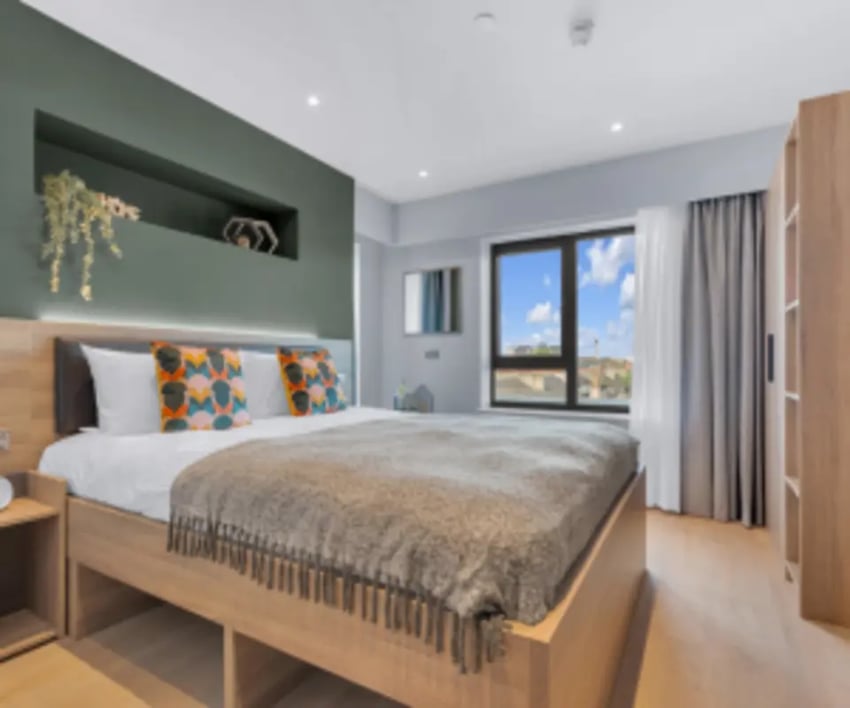 Bed with decorative pillows and wardrobe bedroom at Iconinc The Bonnie in Glasgow Student Accommodation