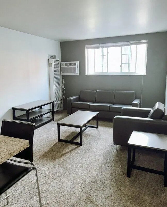 Sofa armchairs coffee tables and shelf living room at University Village in Laredo Student Accommodation