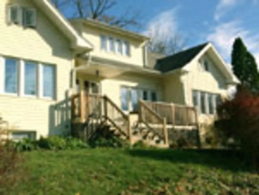 Yellow house with porch and stairs exterior at Ashley Management Corporation in Ithaca Student Accommodation