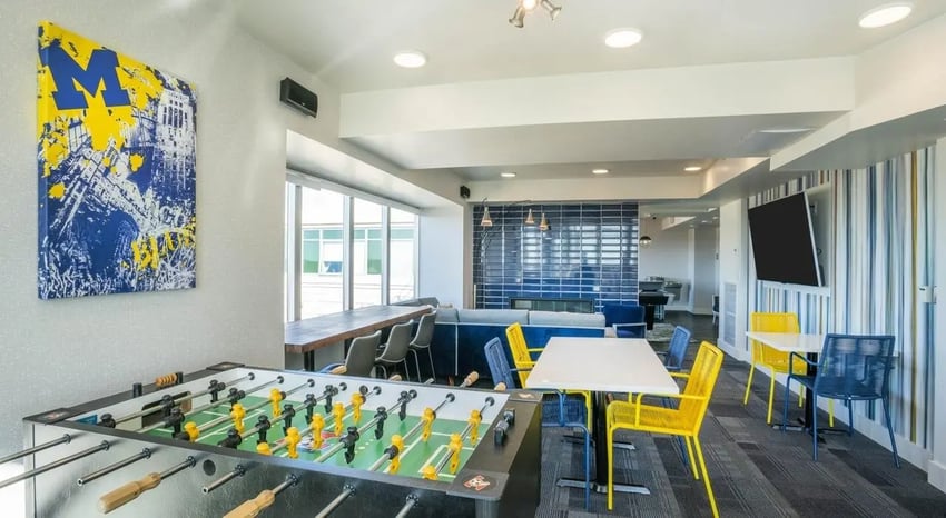 Foosball table artwork tables chairs and sofa living room at Sterling Arbor Blu in Ann Arbor Student Accommodation