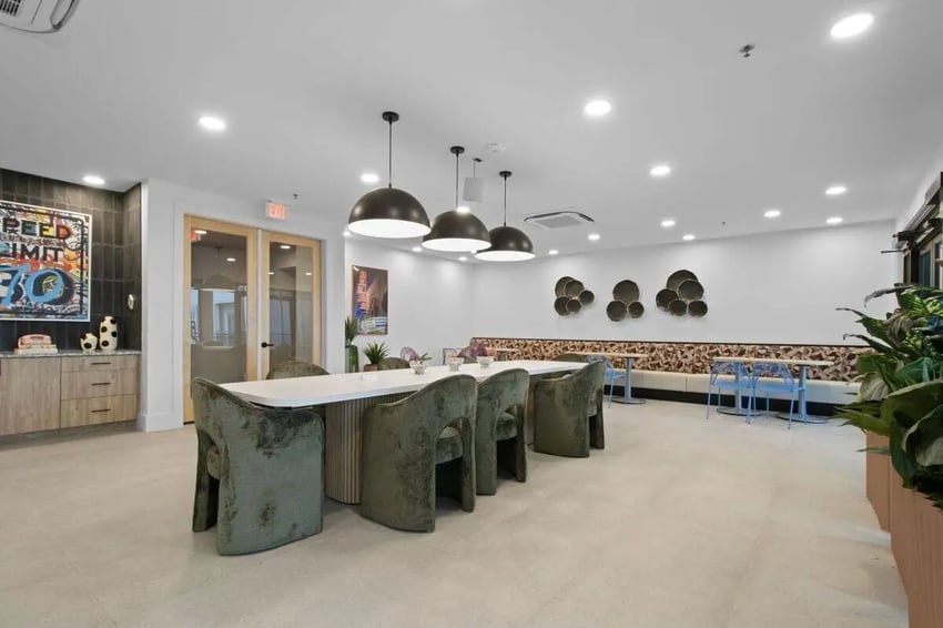 Dining table with green chairs and art decor. at UNITi Bishop Arts in Dallas Student Accommodation