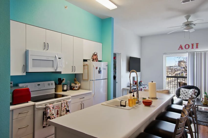 White cabinets microwave stove refrigerator kitchen island kitchen at The Q'ube in Springfield Student Accommodation