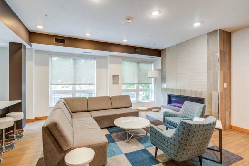 Sectional sofa with patterned chairs fireplace living room at The Knoll Dinkytown in Minneapolis Student Accommodation