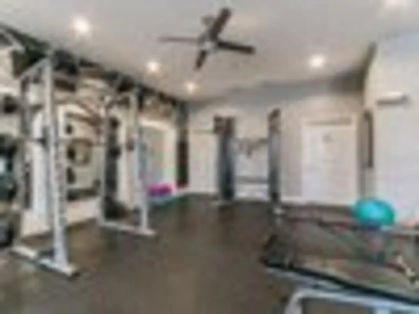 Weight racks and bench gym area at The Grove Apartments Ames in Ames Student Accommodation