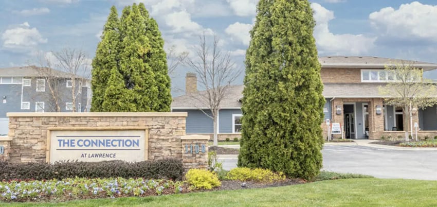 Stone sign trees building exterior at The Connection at Lawrence in Lawrence Student Accommodation
