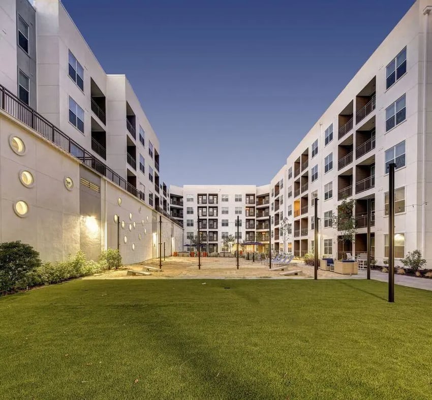 Courtyard with grassy area and apartment buildings exterior at The Lyndon in San Marcos Student Accommodation