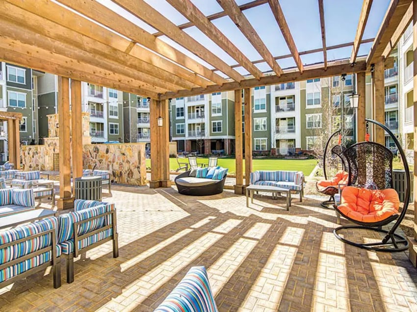 Pergola seating and swings with apartment buildings exterior at 160 Ross in Auburn Student Accommodation