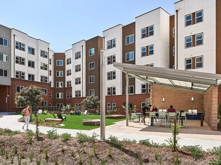 Apartment buildings with patio tables and grills exterior at Plaza Verde in Irvine Student Accommodation