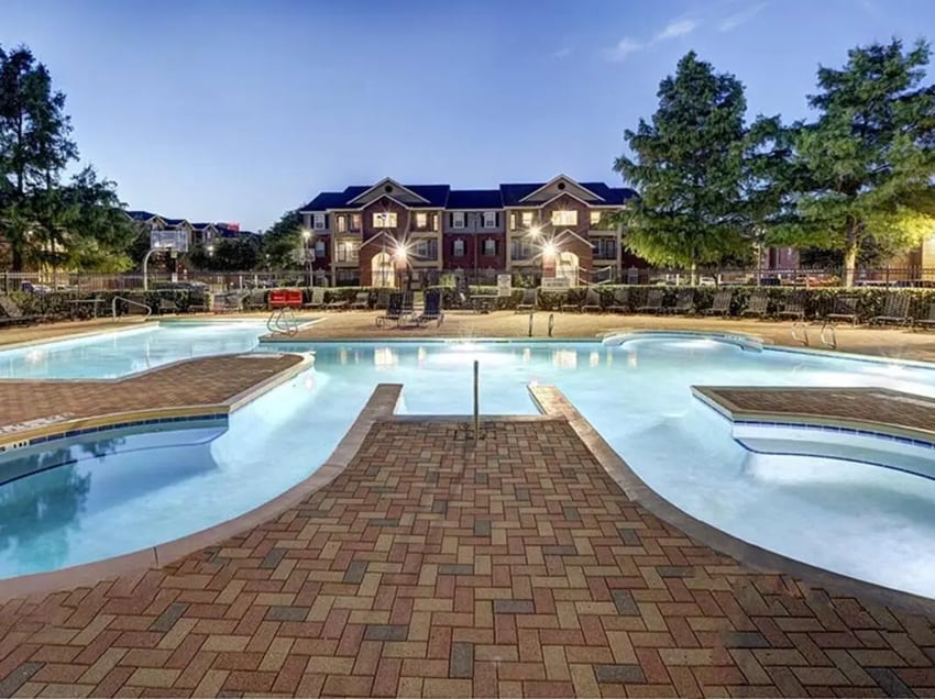 Pool with lounge chairs building exterior at University Trails in Lubbock Student Accommodation