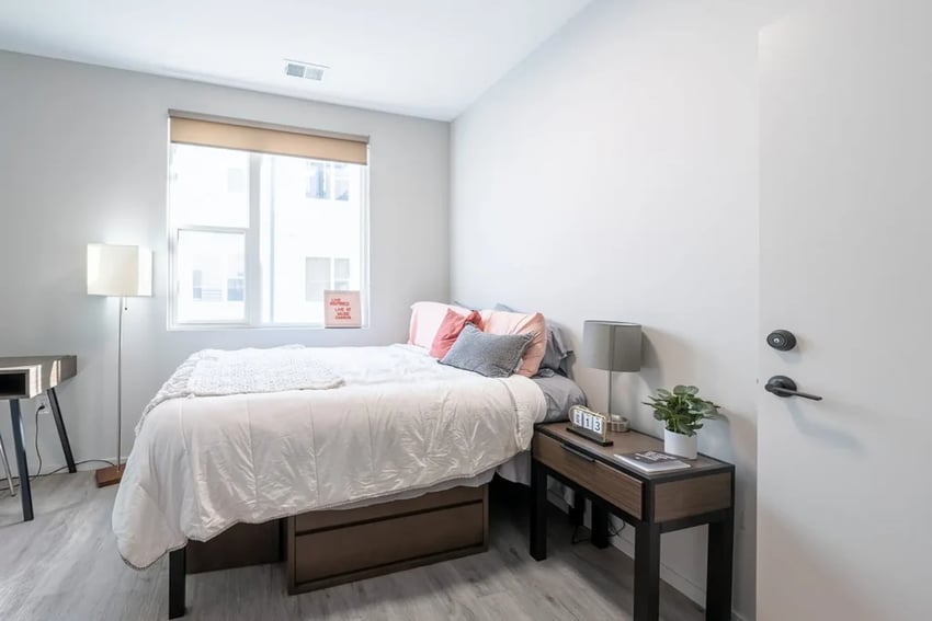 Bed desk lamp pillows nightstand plant Bedroom at Muse Omaha in Omaha Student Accommodation