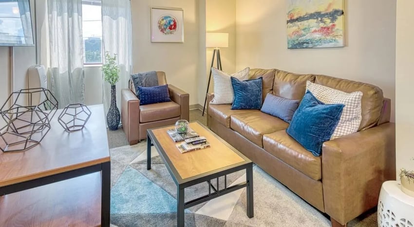 Brown leather sofa coffee table armchairs living room at 100 Midtown in Atlanta Student Accommodation