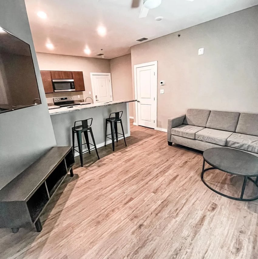 Sofa bar stools coffee table living room at Fireside District Apartments in Stephenville Student Accommodation