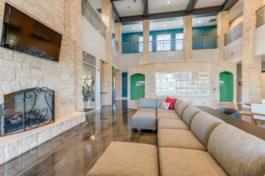 Large sectional sofa television fireplace living room at Campus Village Apartments in College Station Student Accommodation