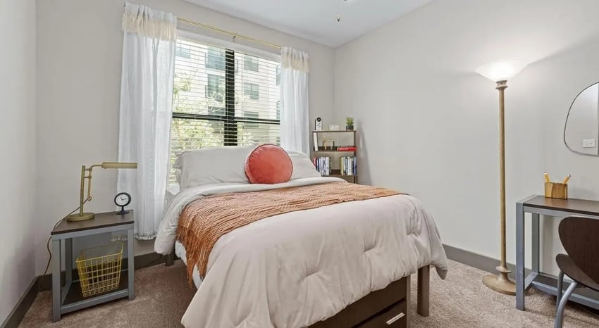 Bed desk lamp bookshelf and pillows bedroom at Accolade Athens in Athens Student Accommodation