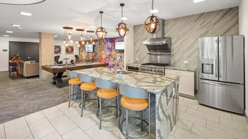 Island kitchen with bar stools pool table living area at Varsity on K Apartments in Washington Student Accommodation