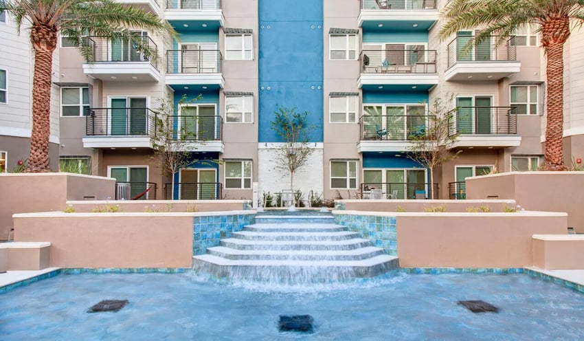 Apartment building with balconies and tiered fountain exterior at Cascades Luxury Apartments in Gainesville Student Accommodation
