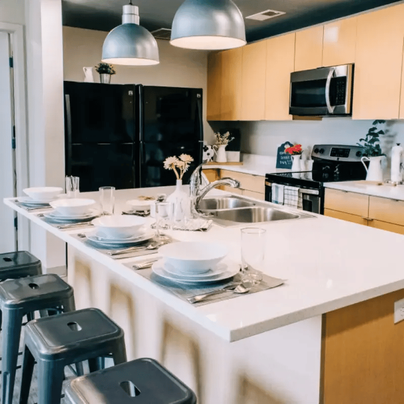 Dining table with bar stools and kitchen island kitchen at Cedars Women's Housing in Rexburg Student Accommodation