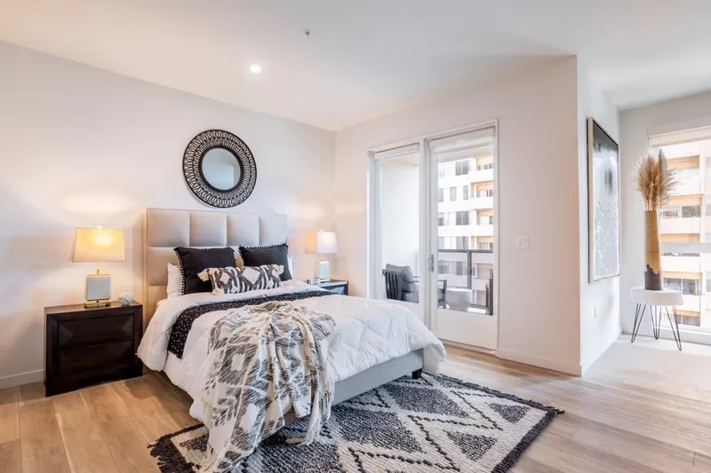Bed nightstands lamps mirror patterned rug bedroom at Atlas House Apartments in Los Angeles Student Accommodation