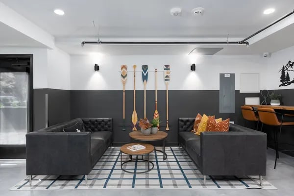 Two black sofas plaid rug paddles wall decor living room at Juno Studios in Seattle Student Accommodation