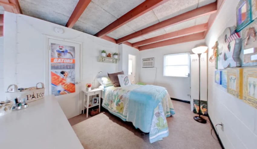 Bed with patterned quilt and bedside table bedroom at Arbor Lofts in Gainesville Student Accommodation
