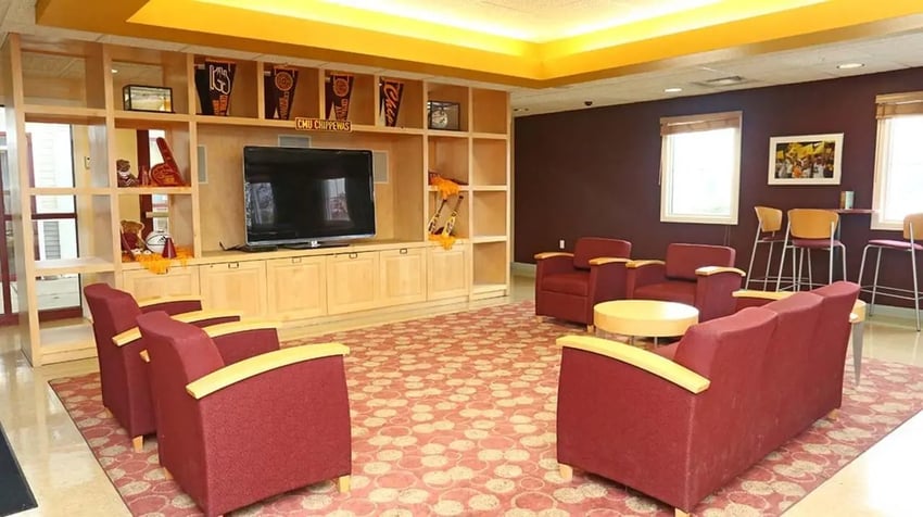 Sofa chairs TV shelf and two windows lounge area at Village at Bluegrass in Mount Pleasant Student Accommodation