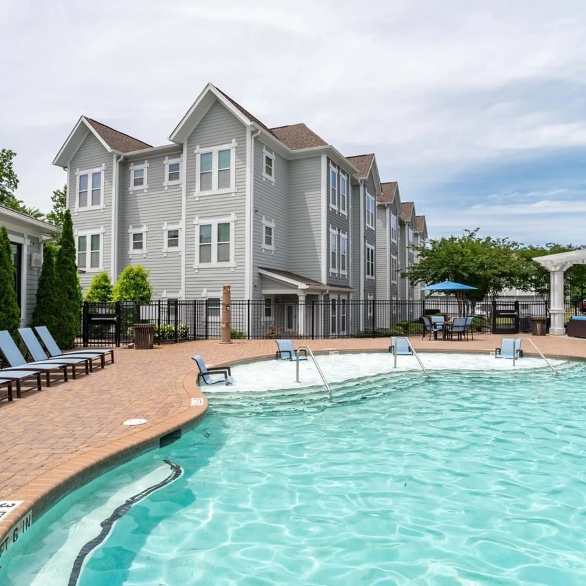 Apartment buildings poolside lounge chairs patio and pool exterior at Millennium One Apartments in Charlotte Student Accommodation