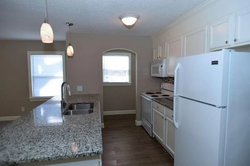 Granite countertop sink white fridge stove kitchen at Campus Walk at ECU in Greenville Student Accommodation