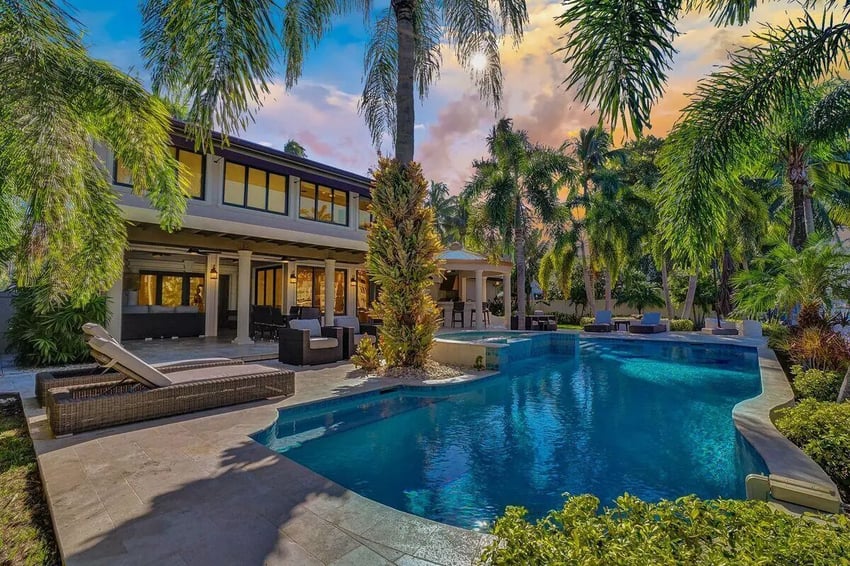 Resort style pool with lounge chairs and palm trees exterior at Carpediem Homes in Dallas Student Accommodation