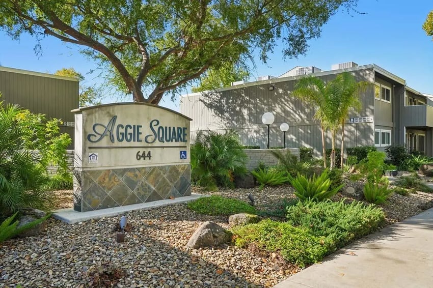 Aggie Square sign with apartment buildings exterior at Aggie Square Apartments in Davis Student Accommodation