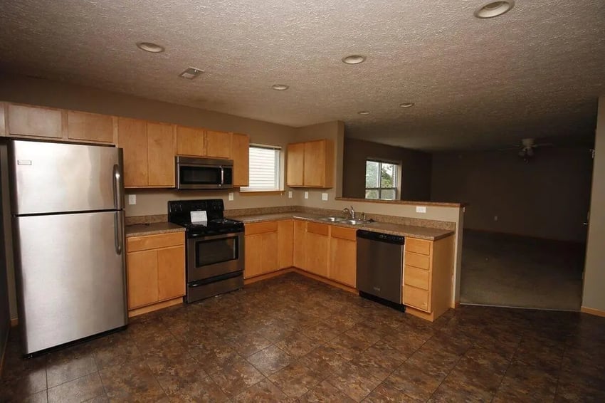 Stainless steel appliances wooden cabinets floor kitchen at Conner Crossing Apartments -"The Porches" in West Lafayette Student Accommodation