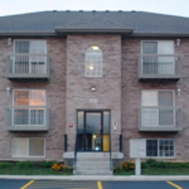 Brick building balconies windows stairs exterior at Aspen Court Apartments in Macomb Student Accommodation