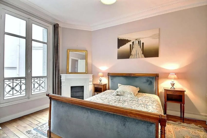 Bed fireplace mirror artwork bedside table bedroom at Apartment in Rue Damrémont, 75018 Paris, France in Paris Student Accommodation