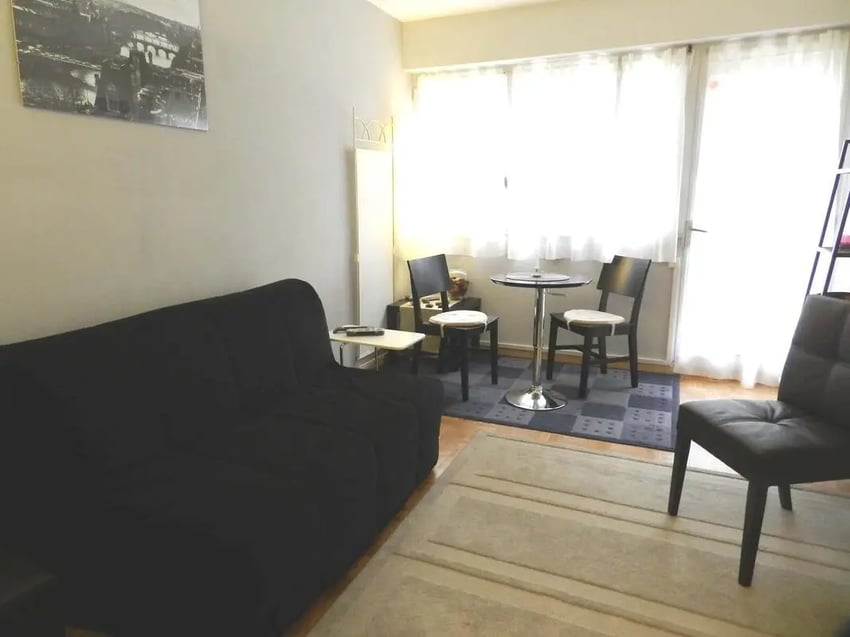 Black sofa high table two chairs living room at Studio in Rue de Dantzig, 75015 Paris, France in Paris Student Accommodation