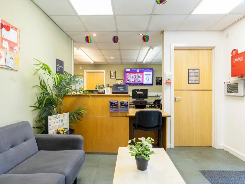 Reception desk with plants couch and screen reception area at Europa in Liverpool Student Accommodation