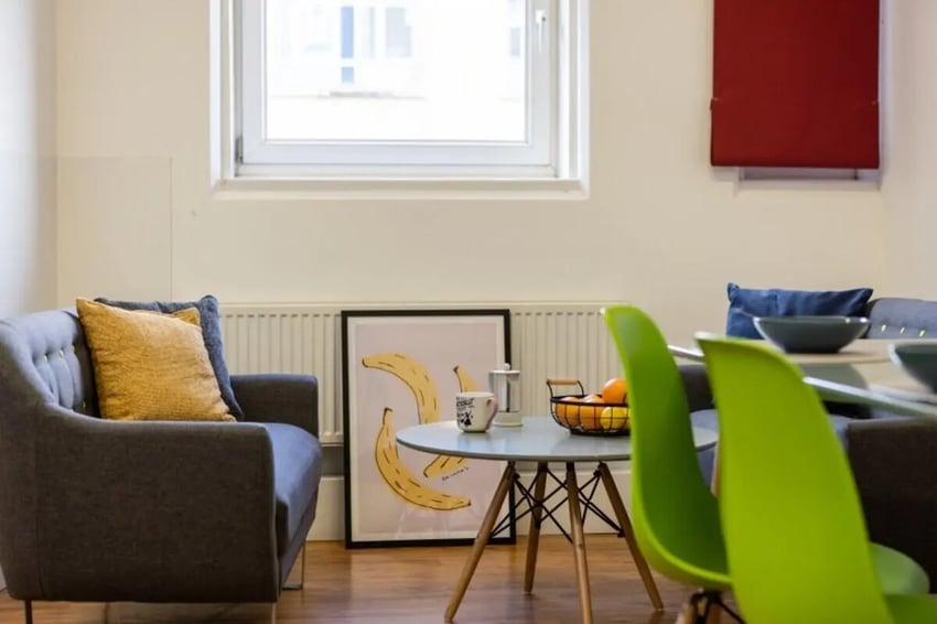 Sofa, artwork, table, chairs, fruit basket, living area at Cranborne House in Bournemouth Student Accommodation