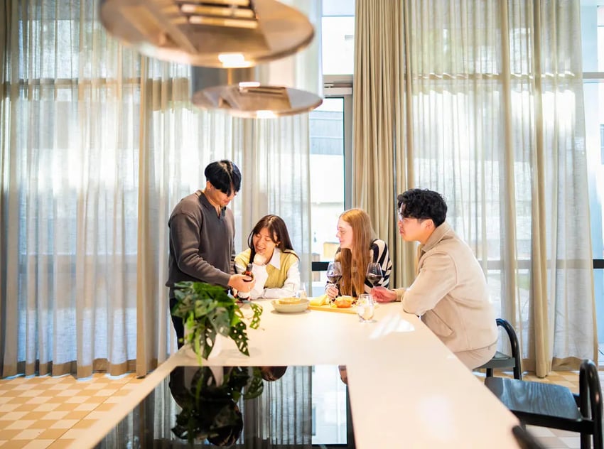 Four students gathered around a counter kitchen at The Switch Lachlan Macquarie Park in Sydney Student Accommodation
