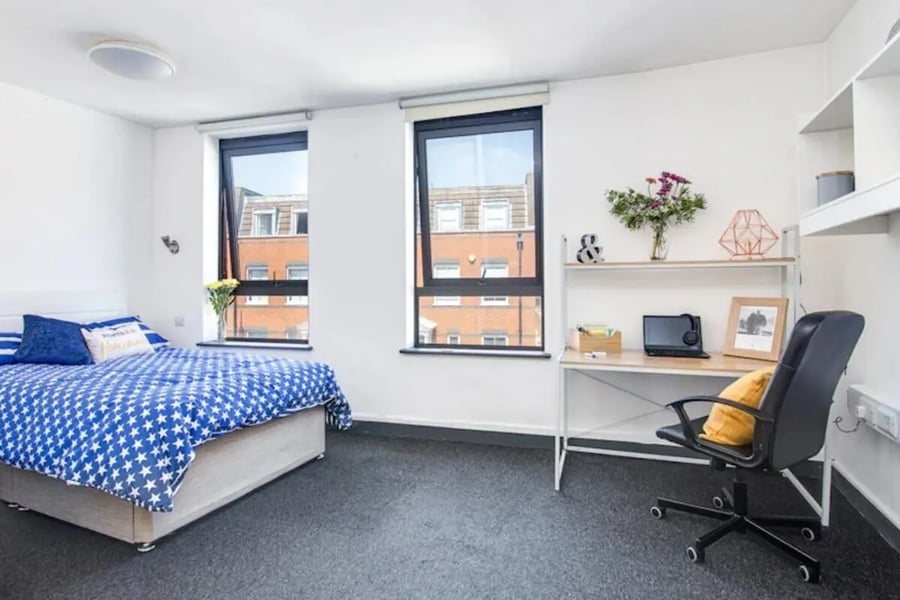Bed desk chair and flowers bedroom at Fulham Palace Studios in London Student Accommodation