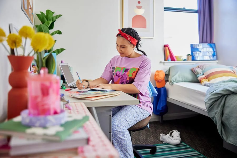 Student studying at desk with laptop and bed bedroom at Mountain x Scape in Sydney Student Accommodation