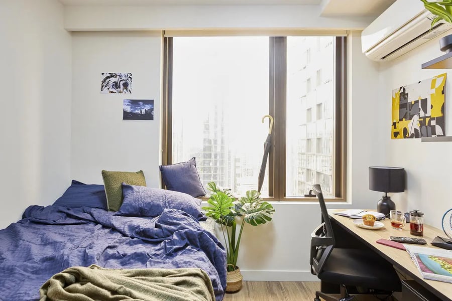 Bed desk plant window air conditioner bedroom at Scape La Trobe in Melbourne Student Accommodation