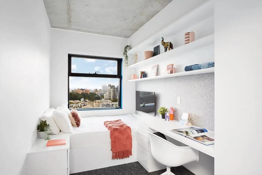 Bed desk and shelves with cityscape view bedroom at Scape Carlton in Melbourne Student Accommodation