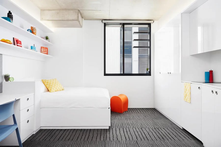 Bed desk shelves kitchen window orange stool bedroom at Scape South Bank in Brisbane Student Accommodation
